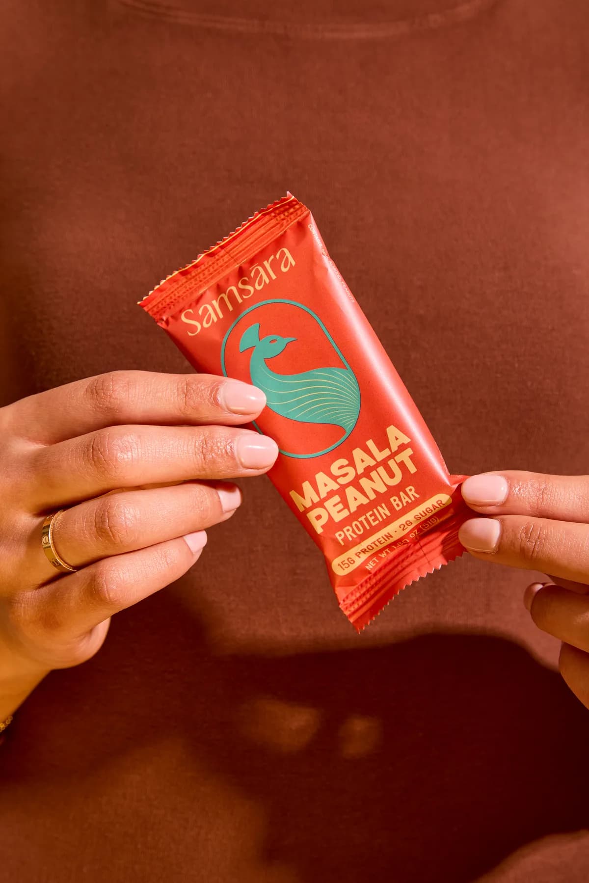 Hands holding a Masala Peanut protein bar